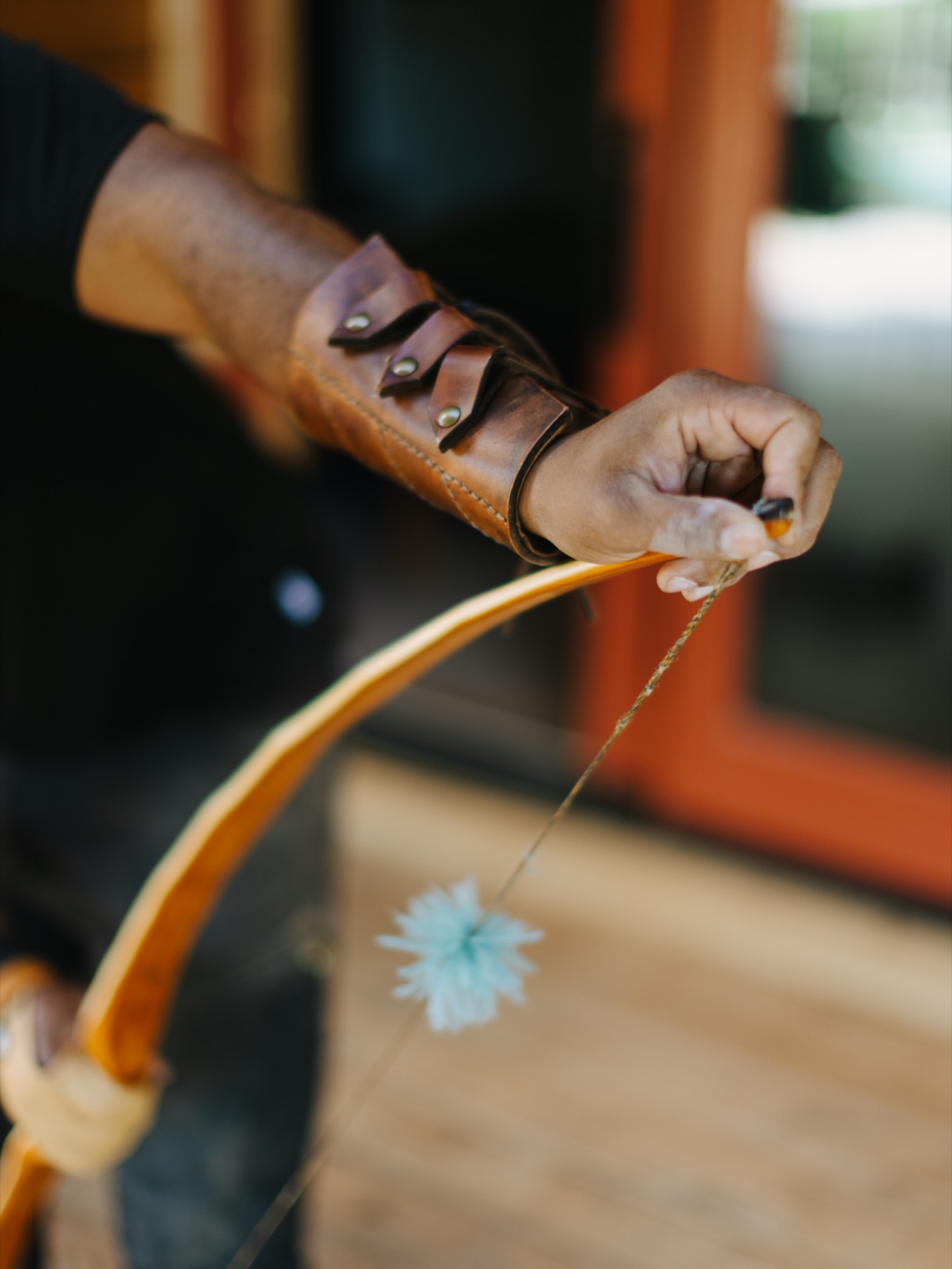 Hands bracing a finished bow to slip the string into the nock.